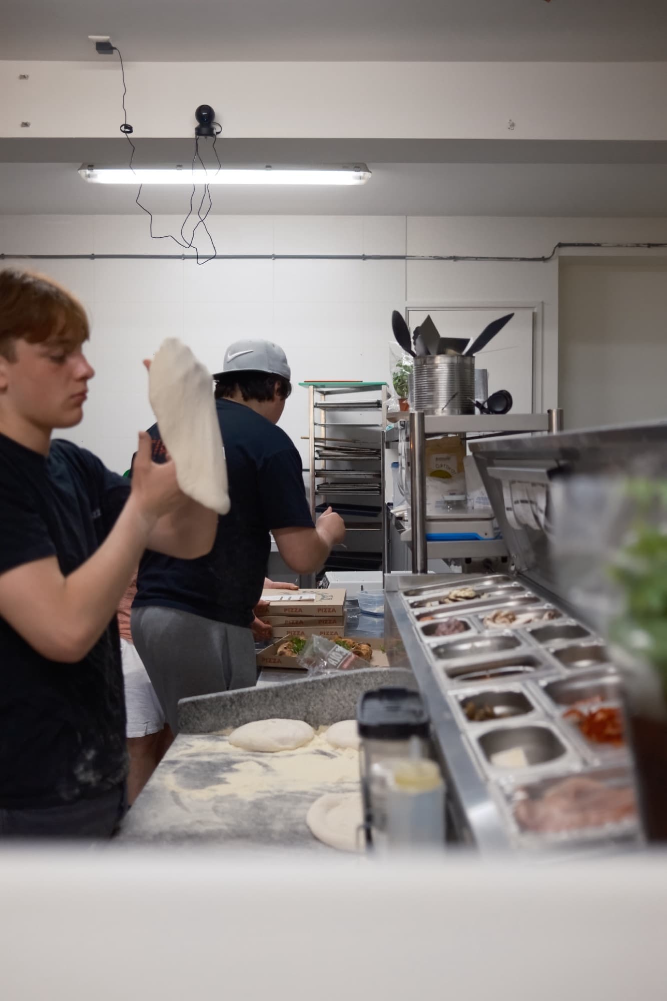A base being stretched by hand over the floured counter