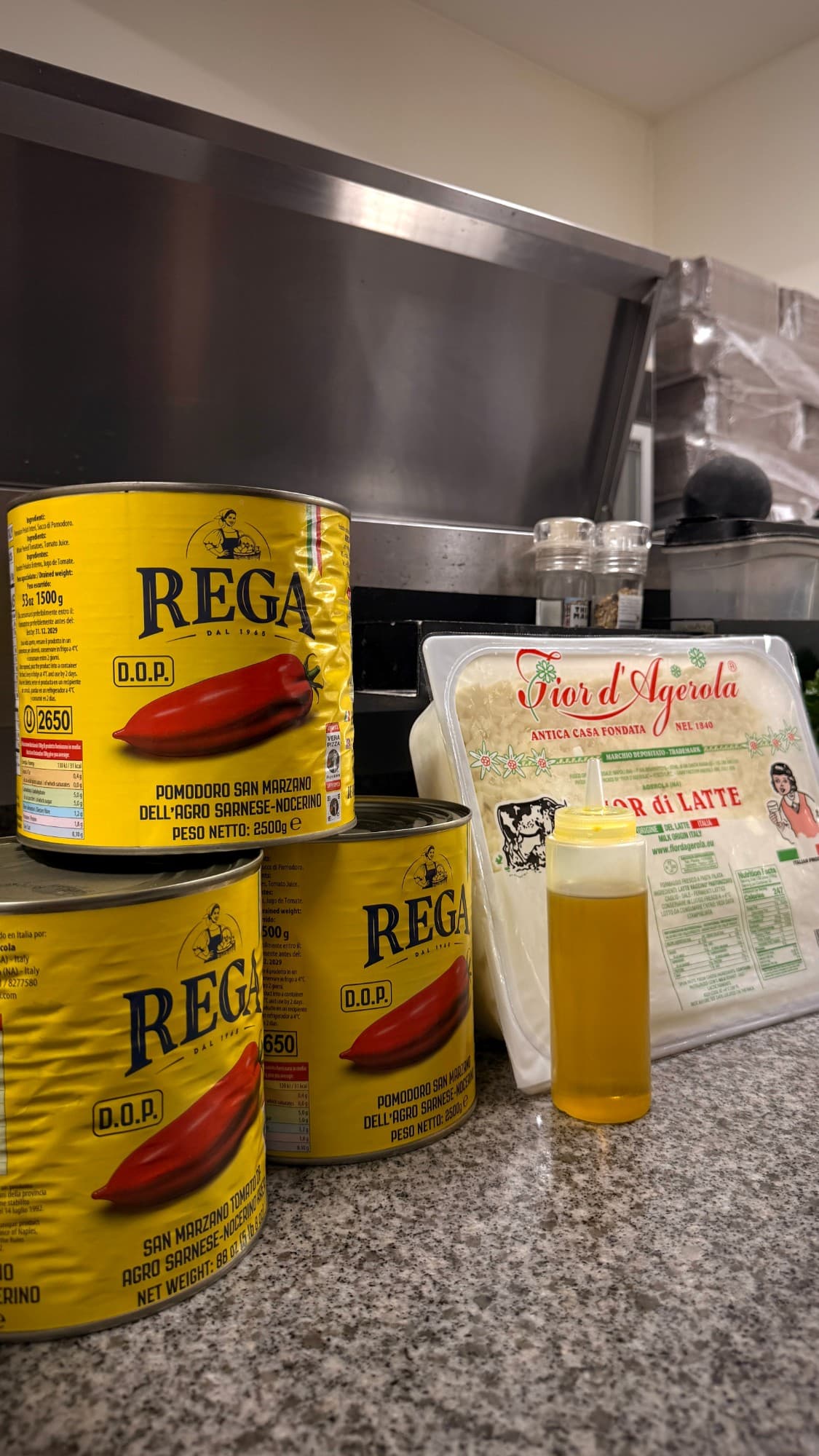 Tins of San Marzano D.O.P. tomatoes next to a pack of fior di latte mozzarella